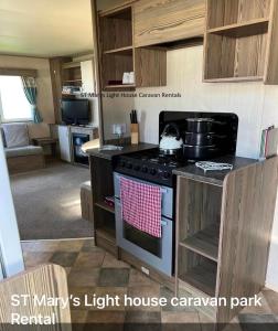 a kitchen with a stove top oven in a room at St Marys Light house, Caravan Rentals in Whitley Bay