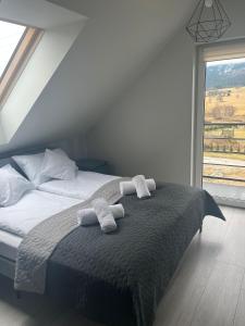 1 dormitorio con 1 cama con 2 toallas en All Season Ski&Bike - domki 4km od Zieleńca en Lasowka