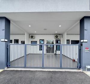 uma entrada para um edifício com um portão azul em The Moment Homestay # WIFI TV Washer em Taiping