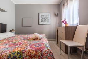 1 dormitorio con 1 cama y 1 silla en Bettatur Apartament Tarraco, en Tarragona