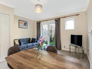 a living room with a table and a couch at Pass the Keys Cul-de-sac Charm: Terrace Home in Loughton