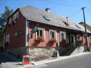 a red building with flower boxes on the windows at Penzion Pomodoro in Vrbno pod Pradědem