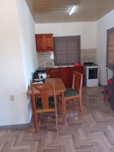 een keuken met een tafel en stoelen en een keuken met een fornuis bij Serenity Divine vastgoed Beheer in Paramaribo