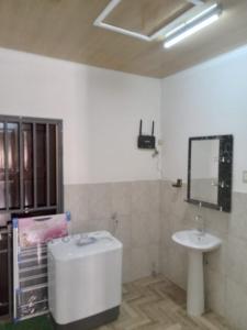 Serenity Divine vastgoed Beheer في باراماريبو: حمام مع حوض ومرآة