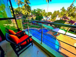 2 stoelen op een balkon met uitzicht op het water bij Hotel Shivam Inn - Near Calangute Beach in Calangute