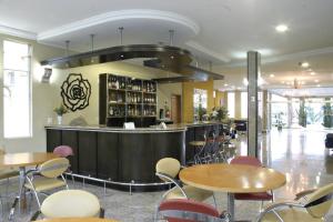 a bar in a restaurant with tables and chairs at Barbur Plaza Hotel in Ponta Grossa