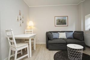 a living room with a couch and a table at nah am Meer, ruhige Lage, gratis Nutzung vom AHOI Erlebnisbad und Sauna in Sellin - Haus Büdnerstube FeWo 2 in Middelhagen