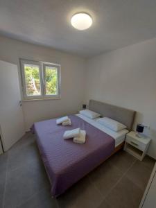 - une chambre avec un grand lit et 2 serviettes dans l'établissement Apartmani NEVA, à Makarska