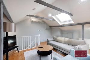 Weybridge - Refurbished Two Bedroom House في يبريدج: غرفة معيشة مع أريكة وطاولة