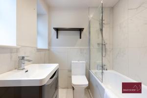 y baño con aseo, lavabo y ducha. en Weybridge - Refurbished Two Bedroom House en Weybridge