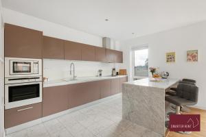 une cuisine avec des placards bruns et un comptoir dans l'établissement Richmond - Luxury 2 Bed Flat, à Londres