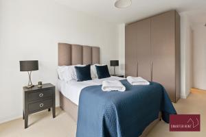 a bedroom with a large bed with a blue blanket at Richmond - Luxury 2 Bed Flat in London