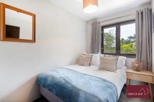 - une chambre avec un lit avec un miroir et une fenêtre dans l'établissement Isleworth - 4 Bed Modern House, à Brentford