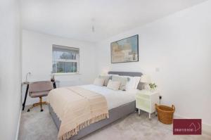 Habitación blanca con cama y escritorio en Sunbury-on-Thames - 4 Bed House en Sunbury Common