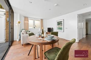 a dining room and living room with a table and chairs at Richmond - 1 Bedroom Apartment - With Garden in Kew