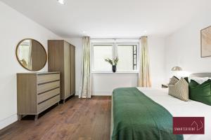 a bedroom with a large bed and a mirror at Richmond - 1 Bedroom Apartment - With Garden in Kew