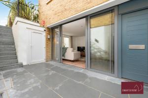 a house with sliding glass doors and a garage at Richmond - 1 Bedroom Apartment - With Garden in Kew