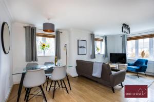 un soggiorno con divano, tavolo e sedie di Englefield Green - Modern 2 bedroom Apartment a Englefield Green