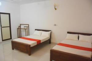 two beds sitting in a room withthritisthritis at Ranathisara Grand Hotel in Kurunegala