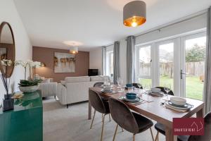 a dining room and living room with a table and chairs at Bracknell - 4 Bedroom House - With Driveway, Garden & Garage in Bracknell