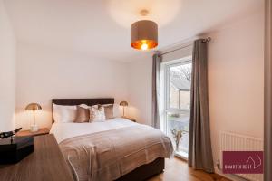 - une chambre avec un grand lit et une fenêtre dans l'établissement Bracknell - 4 Bedroom House - With Driveway, Garden & Garage, à Bracknell