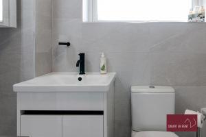 a bathroom with a white sink and a toilet at Woking - 2 Bed Eco-Friendly Home in Horsell