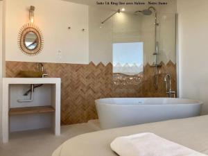 a bathroom with a tub and a sink and a mirror at LaFrenchCasa Clandestina in Marseille +37 photos