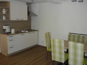 uma cozinha com um lavatório, uma mesa e cadeiras em Ferienwohnungen beim Hotel zur Post, Erlau em Erlau