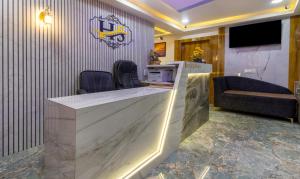 a lobby with a counter with a tv and a couch at Itsy By Treebo - Signature, Nehru Nagar in Ahmedabad