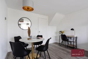 a dining room with a table and black chairs at Knaphill - 2 Bedroom House - Garden & Parking in Chobham