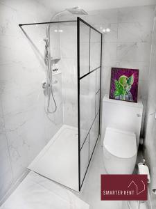 ウォルトン・オン・テムズにあるShepperton - 3 Bedroom Homeの白いバスルーム(シャワー、トイレ付)