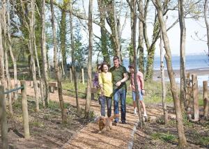 a group of people standing in the woods with a dog at Woodside Bay Lodge Retreat in Wootton Bridge