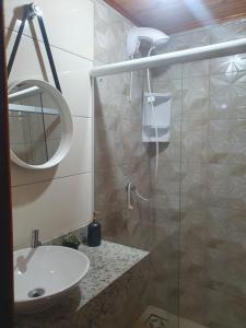 y baño con lavabo y ducha acristalada. en Pousada Viva Serra, en Urubici