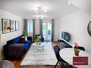 a living room with a blue couch and a table at Knaphill - 2 Bedroom Terrace House - With Garden in Brookwood