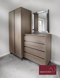 a dresser with a mirror on top of it at Knaphill - 2 Bedroom Terrace House - With Garden in Brookwood