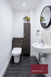 a bathroom with a toilet and a sink and a mirror at Jennett's Park, Bracknell - 2 Bedroom Home - Garden & Parking in Bracknell