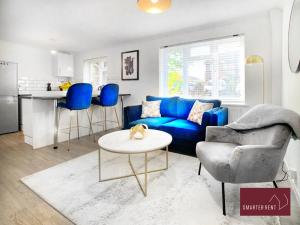 een woonkamer met een blauwe bank en een tafel bij Lightwater - 1 Bedroom Terraced House in Bagshot