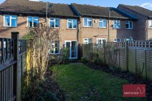 a house with a fence in front of a yard at Bracknell - 2 Bedroom Home With Parking & Garden in Easthampstead