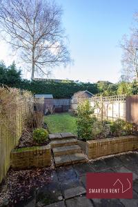 a backyard with a fence and a garden with a path at Bracknell - 2 Bedroom Home With Parking & Garden in Easthampstead