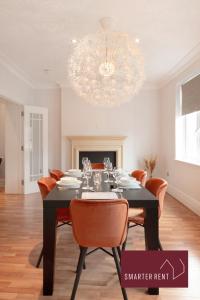 a dining room with a table with chairs and a chandelier at Richmond - 5 Bedroom Townhouse with Parking & Garden in London