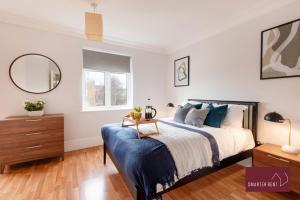 a bedroom with a bed and a table and a mirror at Richmond - 5 Bedroom Townhouse with Parking & Garden in London