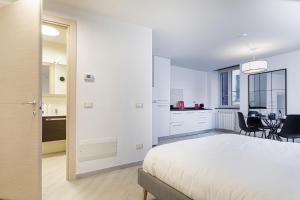 a white bedroom with a bed and a dining room at Goletta Studio by Wonderful Italy in Genova