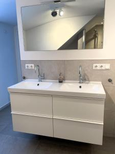 een badkamer met 2 wastafels en een spiegel bij Wohnung mit großer Dachterrasse in Aken