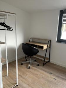 a desk and a chair in a room with a mirror at Wohnung mit großer Dachterrasse in Aachen