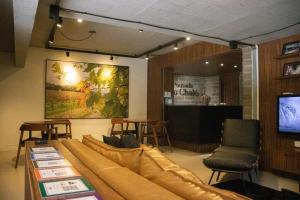 uma sala de estar com um sofá e cadeiras e uma televisão em Pousada Do Chalé em Bento Gonçalves