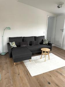 a black couch in a living room with a table at Wohnung mit großer Dachterrasse in Aachen