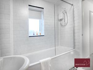 een witte badkamer met een bad en een wastafel bij Bracknell - 1 Bedroom House - With Parking in Bracknell
