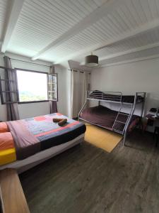 a bedroom with two bunk beds and a window at La ch'tite montagne in Cilaos