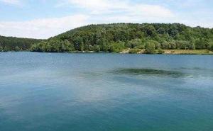 um grande lago azul com árvores ao fundo em Ferienwohnungen Willrich em Blankenheim