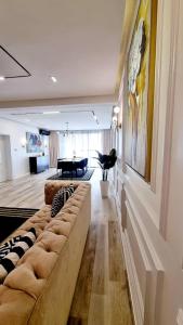 a living room with a long couch and a piano at Orion_apartments in Lagos